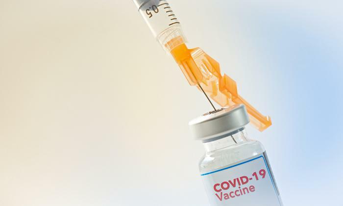COVID-19 vaccine and syringe concept