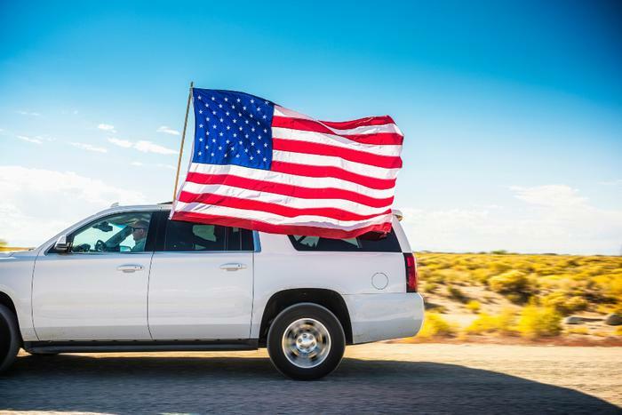 Car driving with American flag