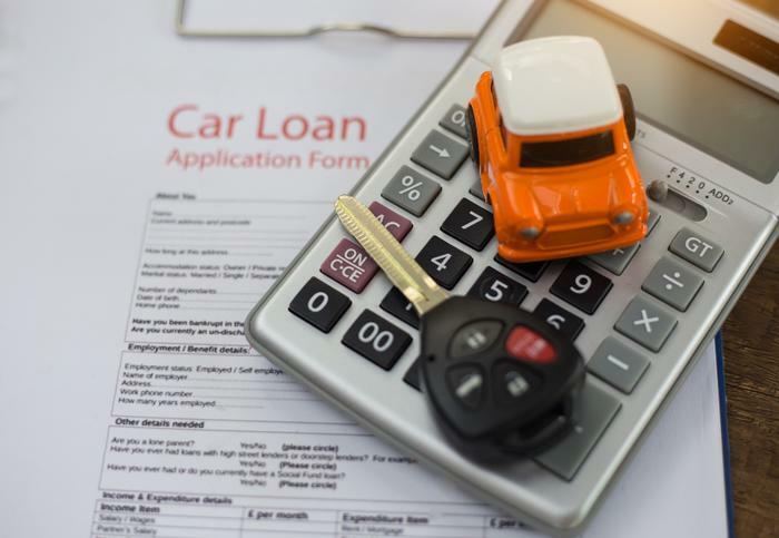 Car loan concept with paperwork and calculator