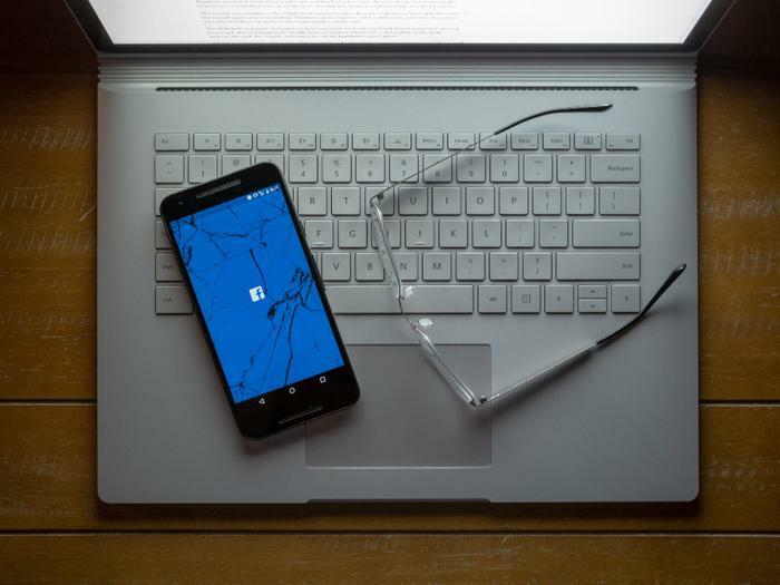 Facebook logo on broken phone and laptop