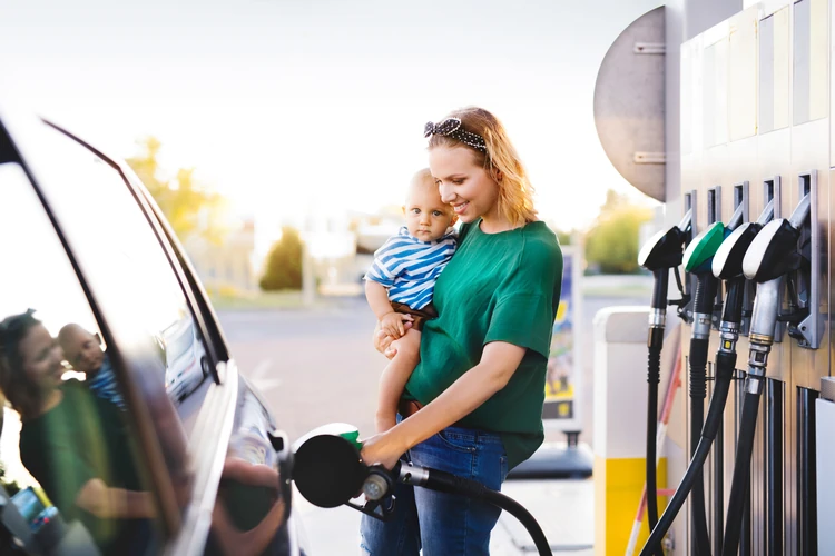 an image of a woman putting gas in her car