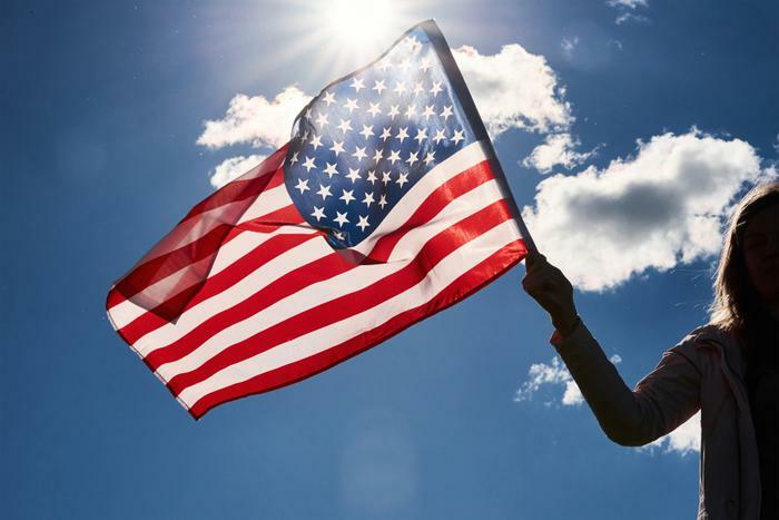 Girl waving U.S. flag outside