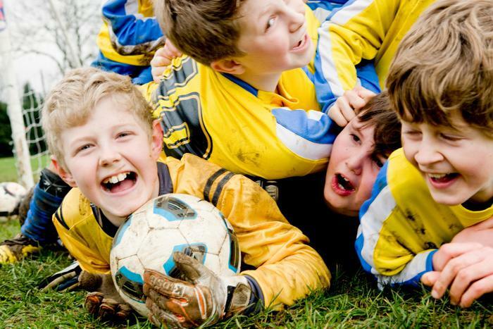 Happy kids playing youth soccer