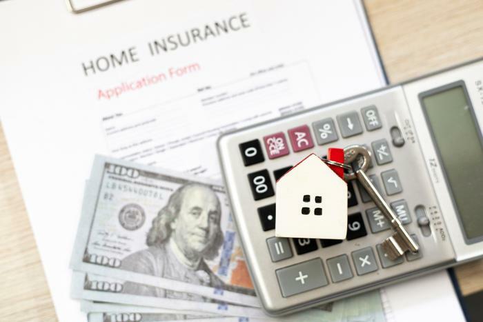 Home insurance concept with calculator and money