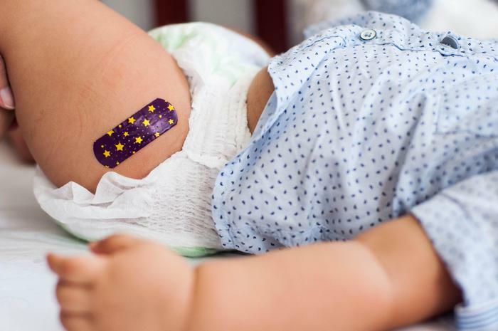 Infant with bandaid on leg from shot