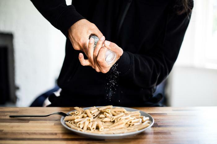 Man adding salt to pasta
