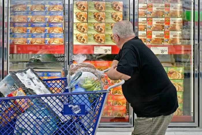 Man grocery shopping for processed foods
