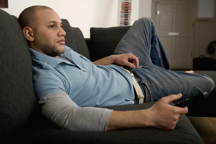 Man sitting on couch watching TV