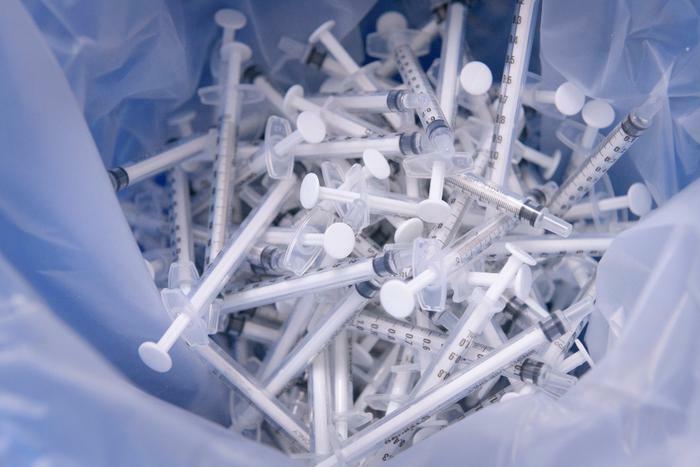 Medical waste concept with syringes in trash
