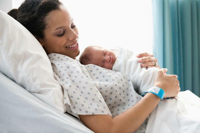 New mom with baby in hospital bed
