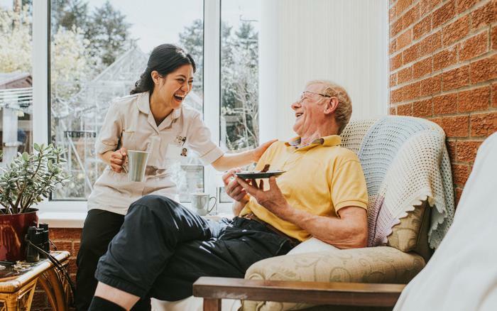 Older man laughing with nurse