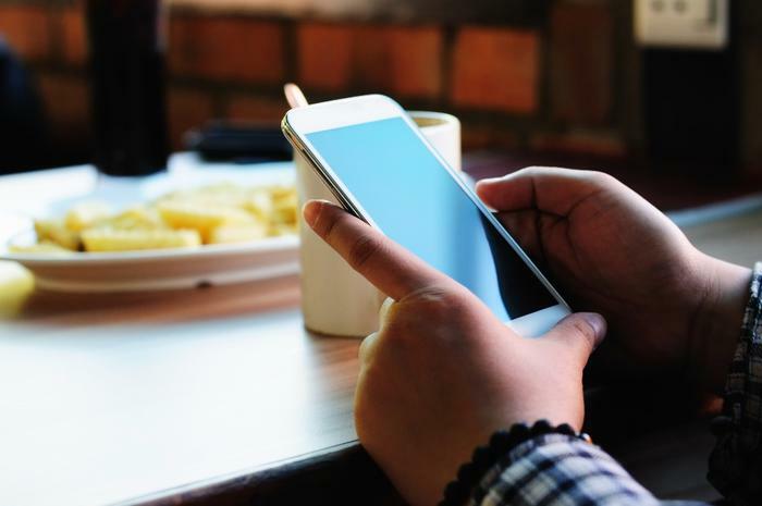 Person holding smartphone at table