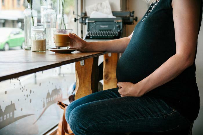 Pregnant woman holding coffee