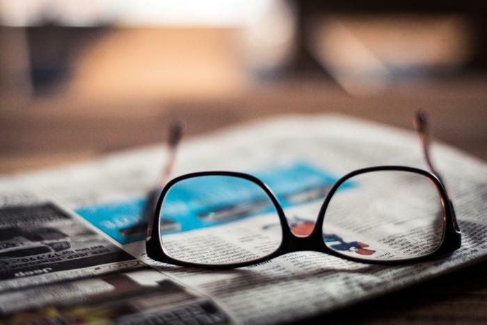 Reading glasses on newspaper