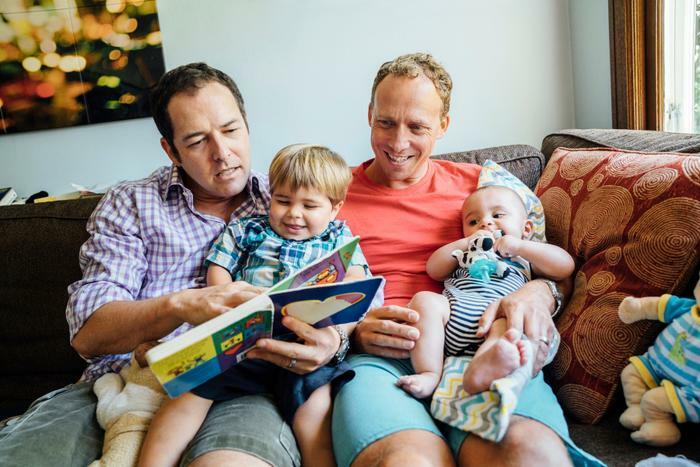 Same-sex couple reading book to children