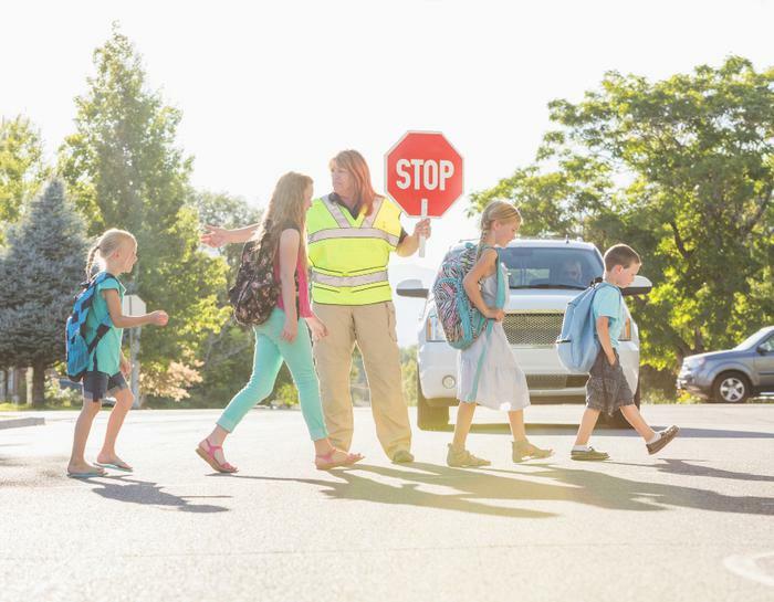 Schoolkids in crosswalk with crossing guard