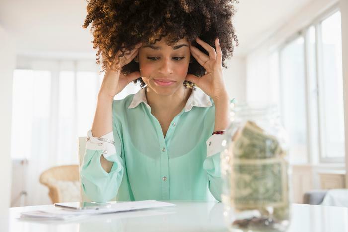 Stressed woman with money in jar