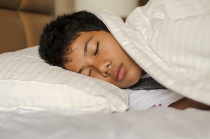 Teen boy sleeping in bed