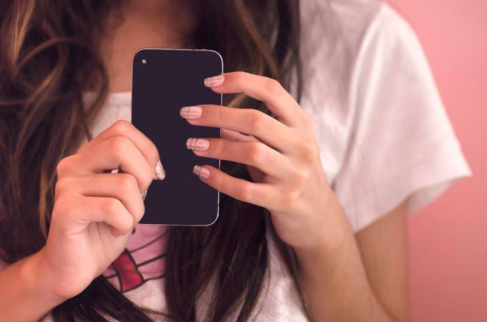 Teen or young girl holding smartphone