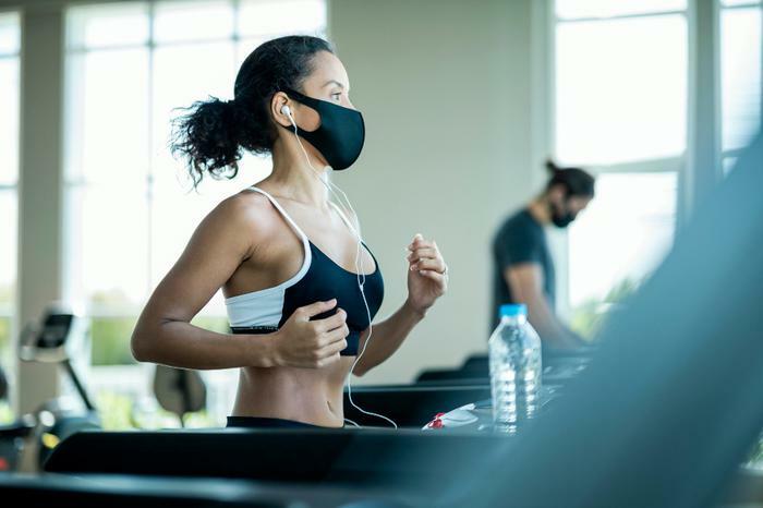 Woman exercising while wearing COVID-19 mask