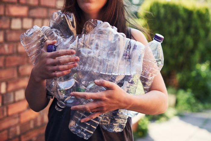 Woman holding plastic bottles for recycling