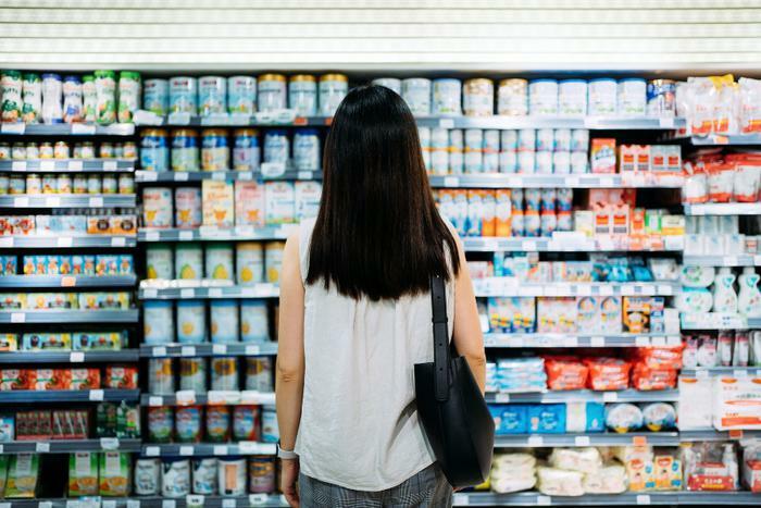 Woman looking at foods in supermarket