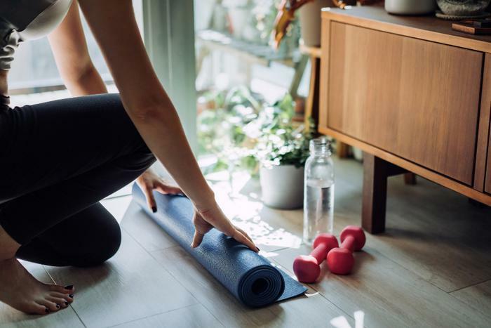 Woman rolling out yoga mat