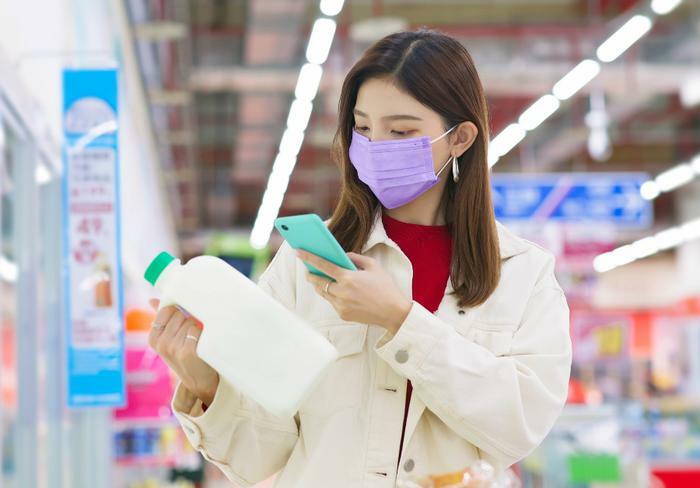 Woman scanning milk with phone
