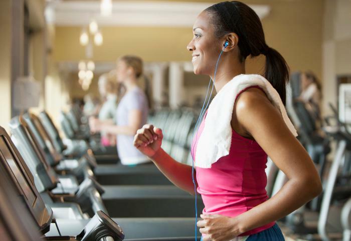 Woman smiling while running on treadmill