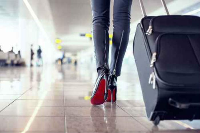 Woman with rolling suitcase in airport