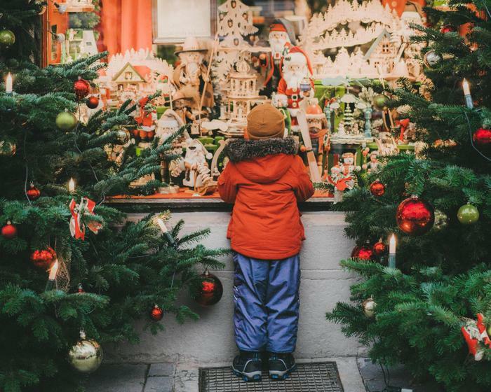 Young boy standing near Christmas trees