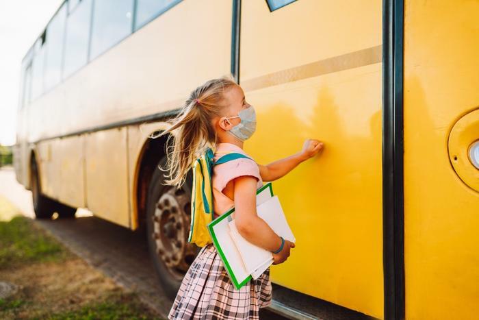 Young girl getting on school bus
