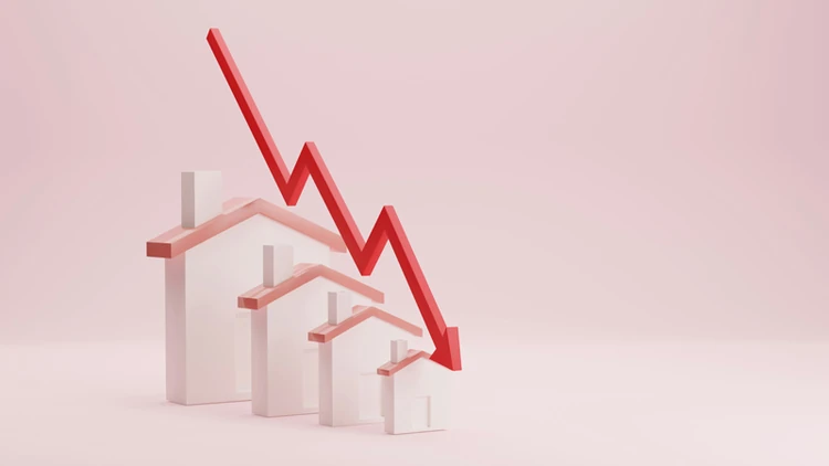 Downward trending chart over a line of houses 