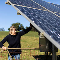 woman confidently checking her solar panels on her property
