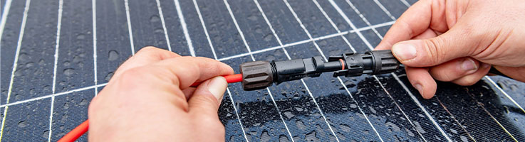 hands of a tech connecting solar panels