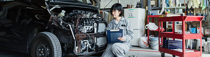 female mechanic inspecting a vehicle