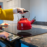 woman making tea on electric stove