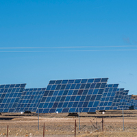 solar panels with tracker on a field under blue sky