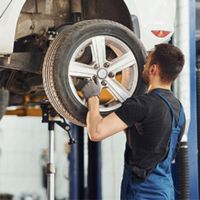 auto mechanic aligning wheels