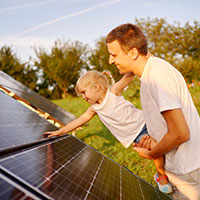 father and daughter looking at solar panels