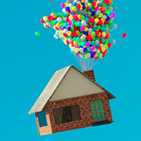 house with balloons tied to it floating through the sky