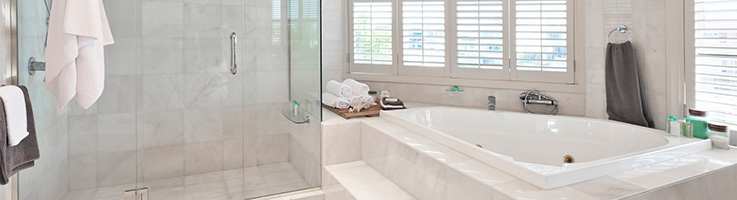white tiled bathroom with large tub and glass shower