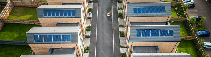 aerial view of houses with solar panels on rooftops