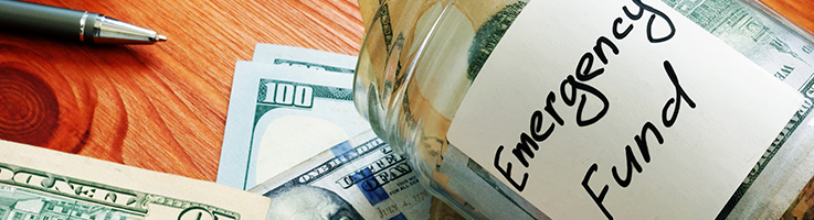 cash in glass jar labeled emergency fund