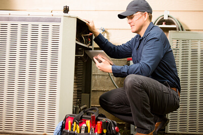 repairman working on air conditioning unit