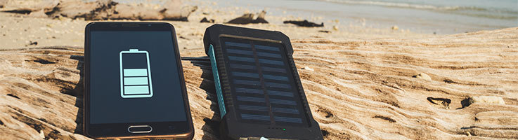 charging  a cellphone on the beach using a solar charger