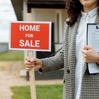 real estate agent holding a for sale sign