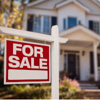 for sale sign in the front yard of a house