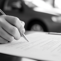 someone signing a document, focused on the hand