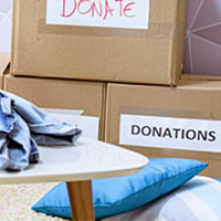 woman sorting and boxing clothes for donation